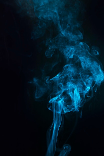 Free photo blue color smoke effect on the black background