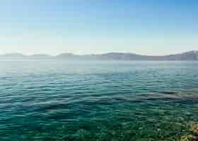 Free photo blue crystal idyllic lake with mountain range against blue sky