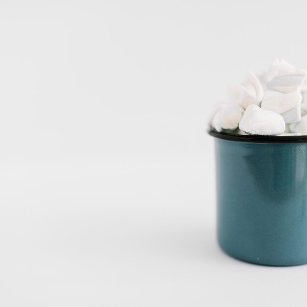 Blue cup with marshmallows on table 