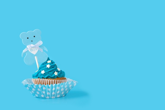 Blue cupcake for baby shower on blue background. Copy space