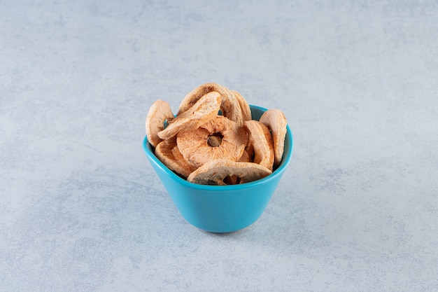 Free photo a blue deep plate with healthy dried fruits on marble.