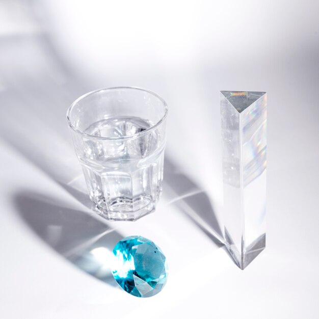 블루 다이아몬드; 긴 크리스탈과 흰색 배경에 그림자와 물 잔