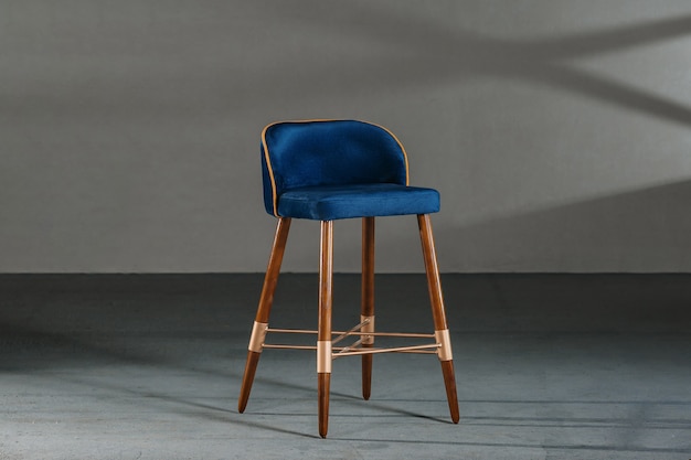 Синий стул для столовой в комнате с серыми стенами
