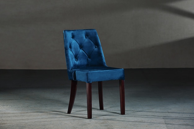 Blue dining room chair in a studio with gray walls