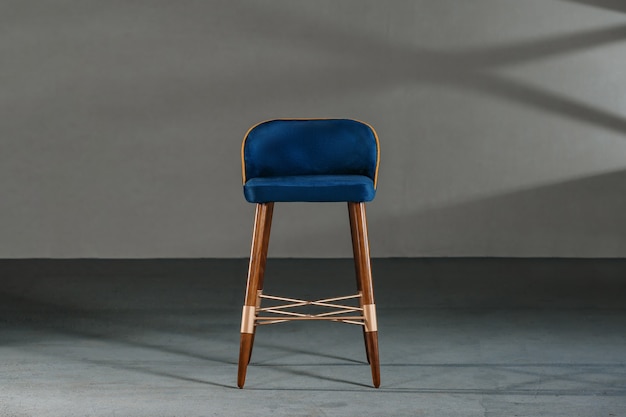 Blue dining room chair in a studio with gray walls