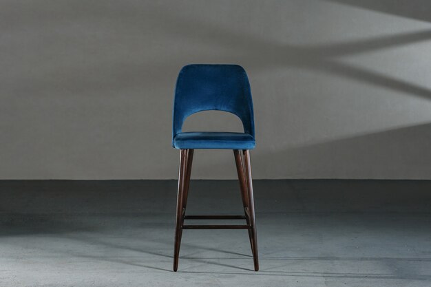 Blue dining room chair in a studio with gray walls