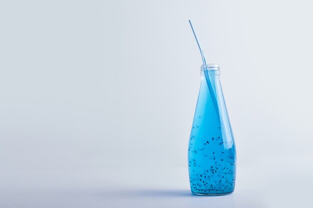 Blue drink in a glass bottle .