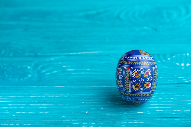 Blue easter egg on wooden surface