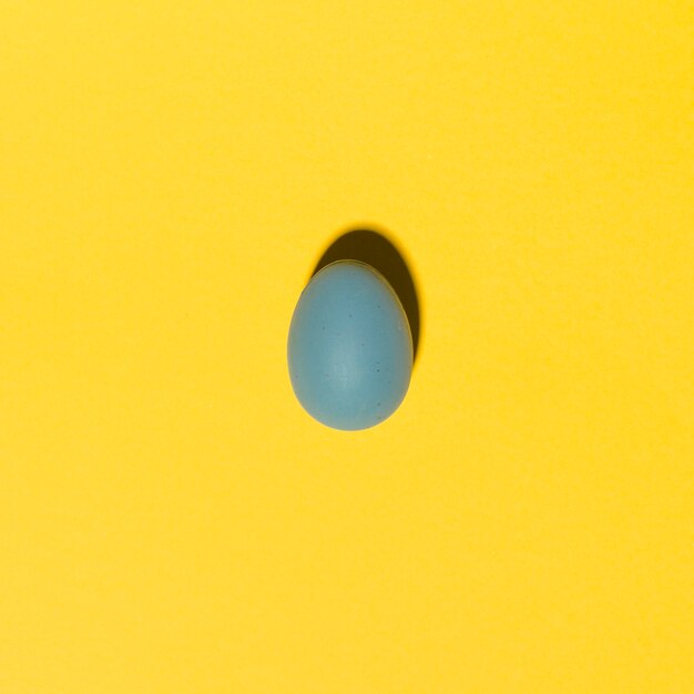 Blue Easter egg on yellow table