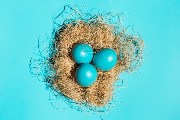 Blue Easter eggs in nest on table