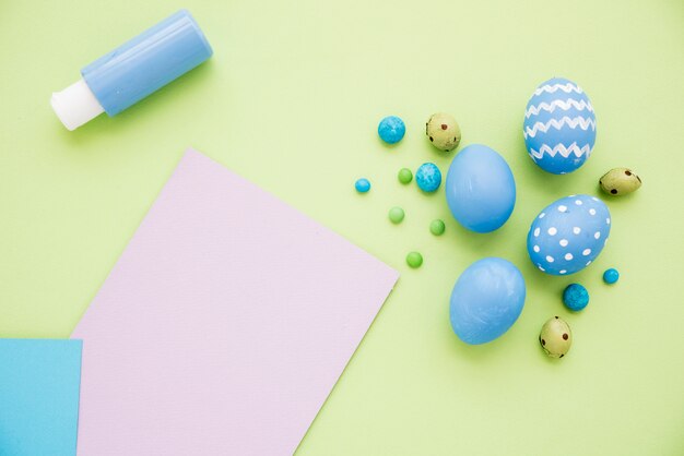 Синие пасхальные яйца с листом бумаги на столе