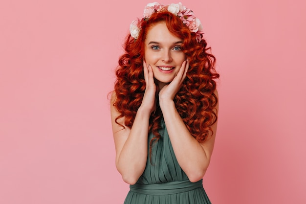 Captivating Portrait of a Blue-eyed Young Woman with a Crown of Flowers, Surrounded by a Pink Space