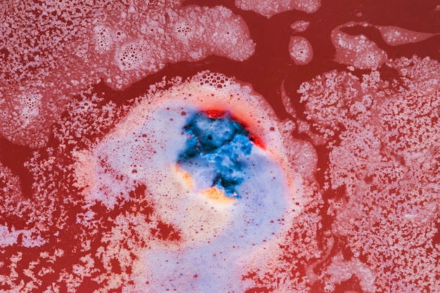 Blue foam on red water