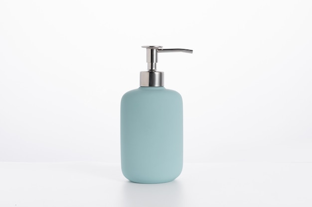 Free photo blue glass soap bottle isolated on a white wall