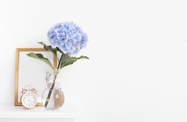 Blue hortensia flowers in the vase with wooden frame in provence interior