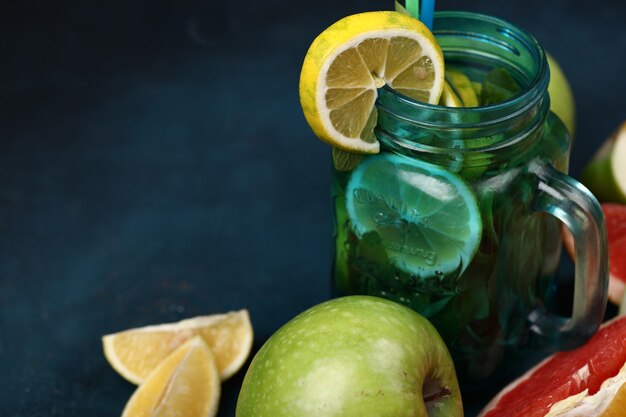 A blue jar of mojito cocktail with lemon slices.