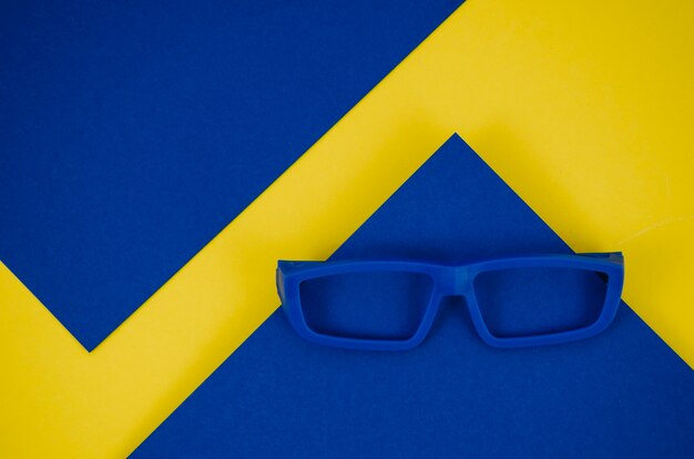 Синие детские очки на синем и желтом фоне