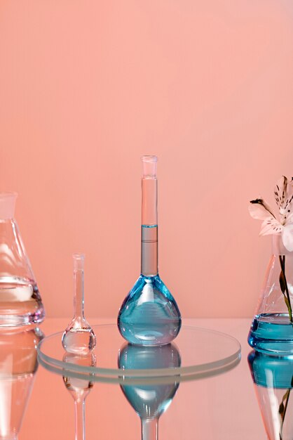 ピンクの背景を持つ実験用ガラス器具の青い液体