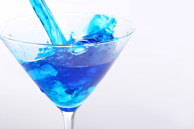 Blue liquid pouring into glass