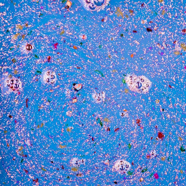 Blue liquid with colourful crumbs