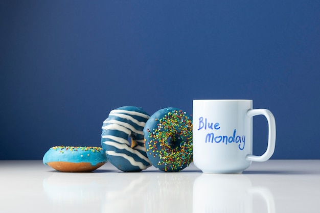 Бесплатное фото Композиция синего понедельника с пончиками