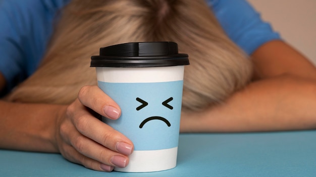 Free photo blue monday concept with sad face on cup