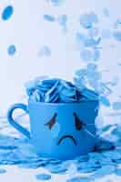 Free photo blue monday with crying mug and paper rain