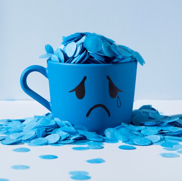 Free photo blue monday with paper rain and teary mug