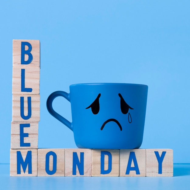 Бесплатное фото Синий понедельник с деревянными кубиками и плачущей кружкой