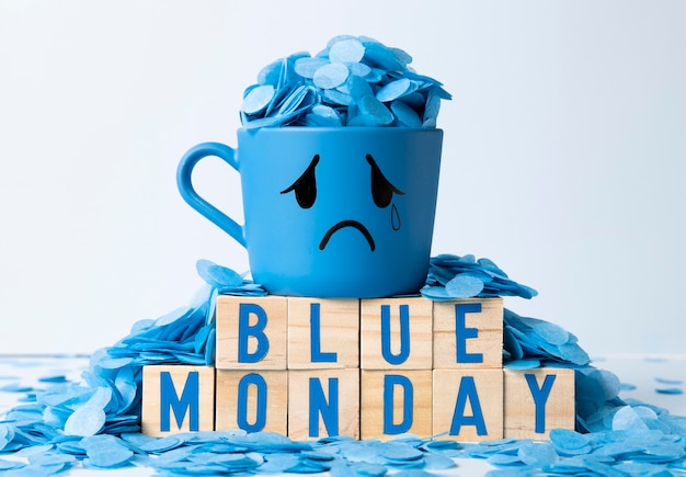 木製の立方体と泣いているマグカップと青い月曜日