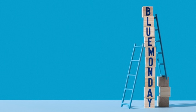 Blue monday with wooden cubes, ladders and copy space