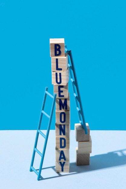 Free photo blue monday with wooden cubes and ladders