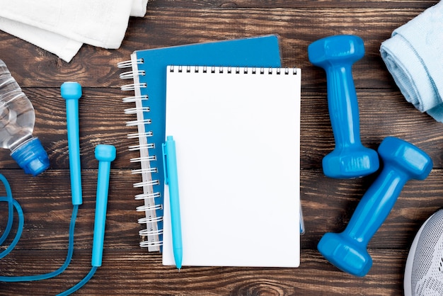 Free photo blue notebook with dumbbells