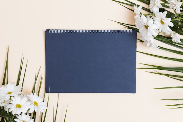 Blue notepad and white flowers