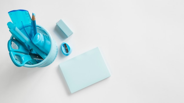 Blue office supplies in cup on table