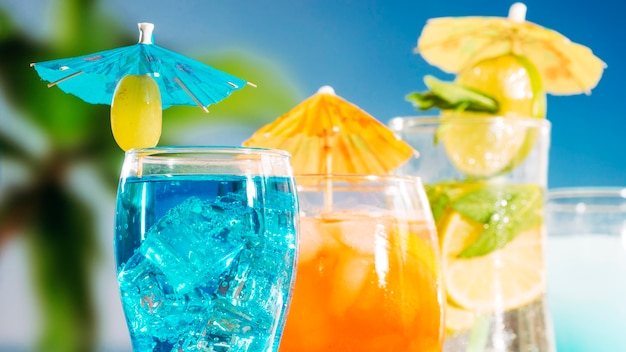 Синие апельсиновые напитки с кусочками лайма и мяты в бокалах