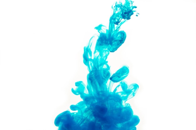 Blue paint diffusing on white background