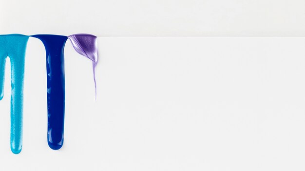 Blue paint dripping on white background