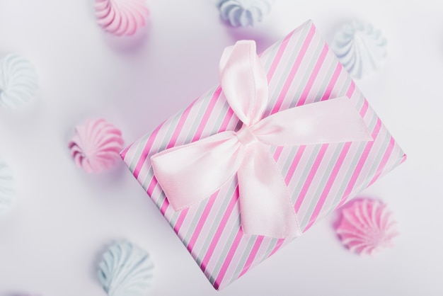 Free photo blue and pink whipped cream around the present box tied with satin ribbon