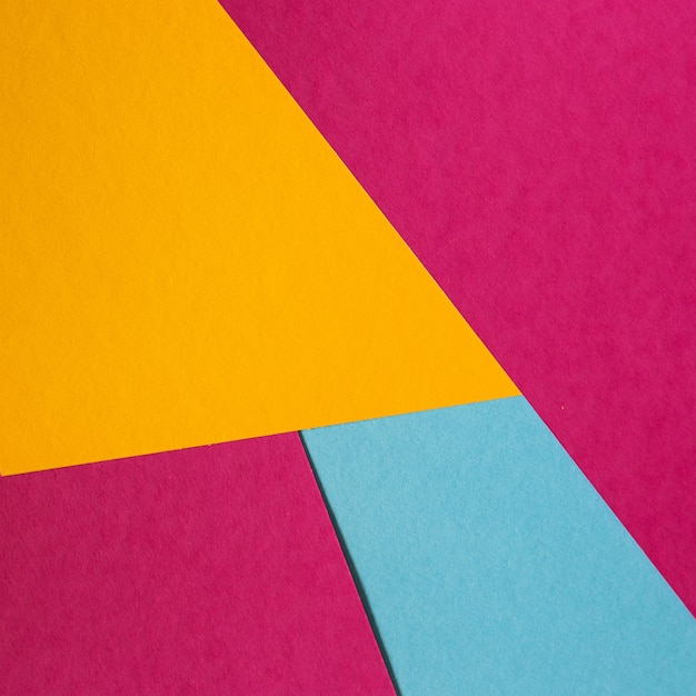 Blue, pink, yellow pastel color paper geometric flat lay background.