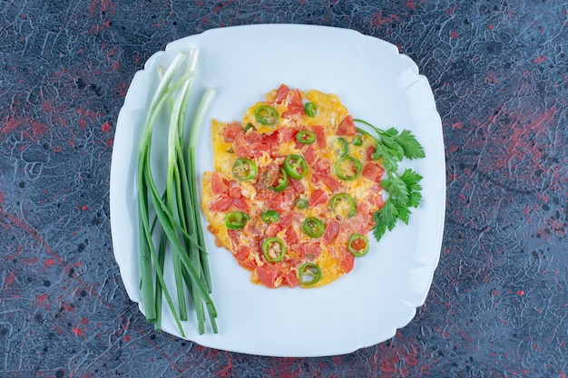 Foto gratuita un piatto blu di uova fritte con verdure.