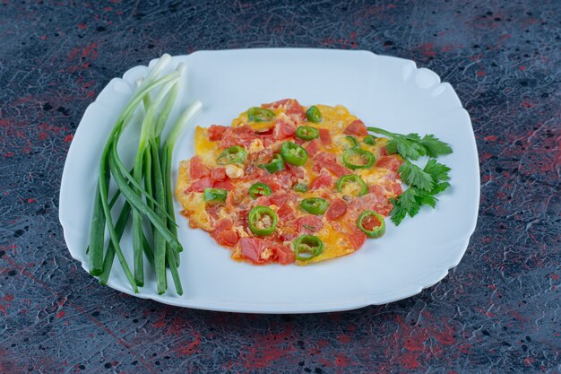 A blue plate of fried eggs with vegetables