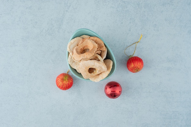 Foto gratuita un piatto blu pieno di frutta sana secca con palline rosse di natale. foto di alta qualità