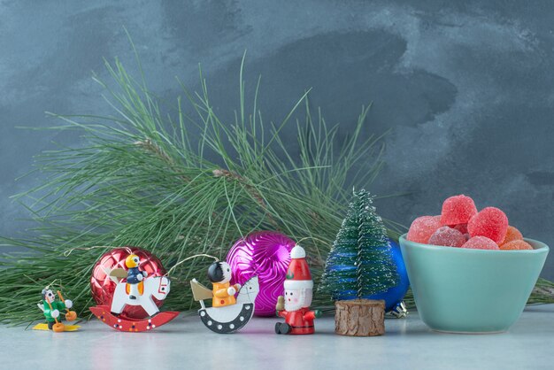 大理石の背景に小さなクリスマスのお祝いのおもちゃとマーマレードの青いプレート。高品質の写真
