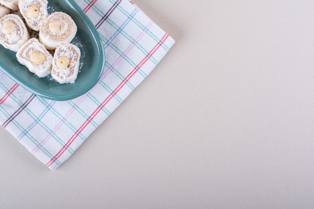 Синяя тарелка сладкого десерта лукум на мраморном фоне. Фото высокого качества