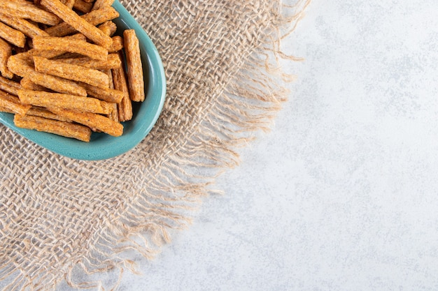 Foto gratuita piatto blu di gustosi cracker croccanti su pietra.