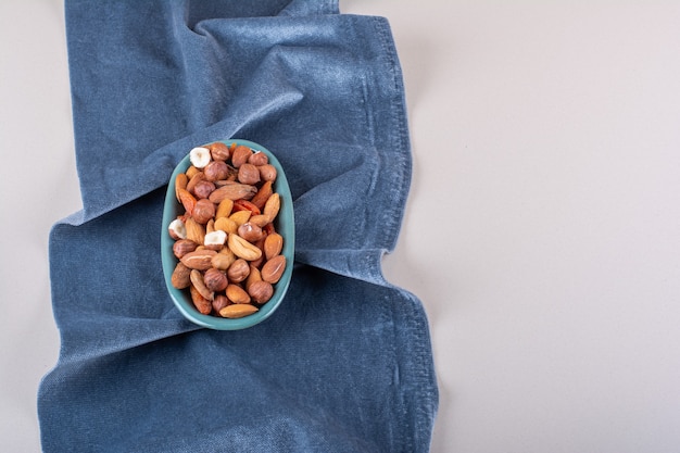 Blue plate of various organic nuts on white background. High quality photo