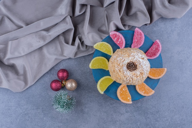 Foto gratuita un piatto blu con una deliziosa torta e caramelle di gelatina zuccherate