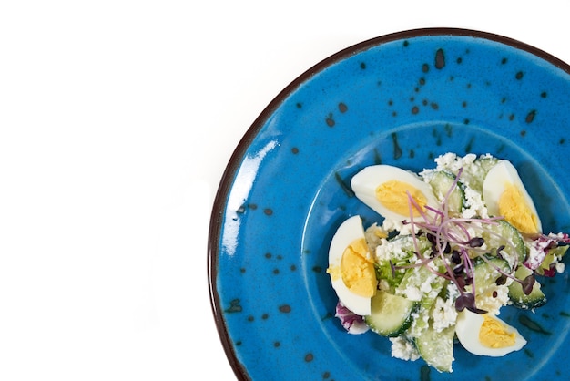 Blue plate with tasty salad eggscucumbercottage cheese