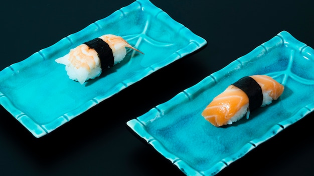 Blue plates with sushi on a black background